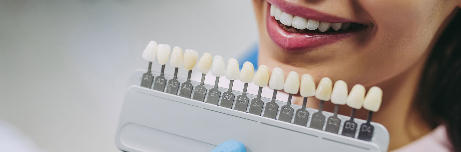 Close up portrait of young woman in dentist chair choosing tooth implants