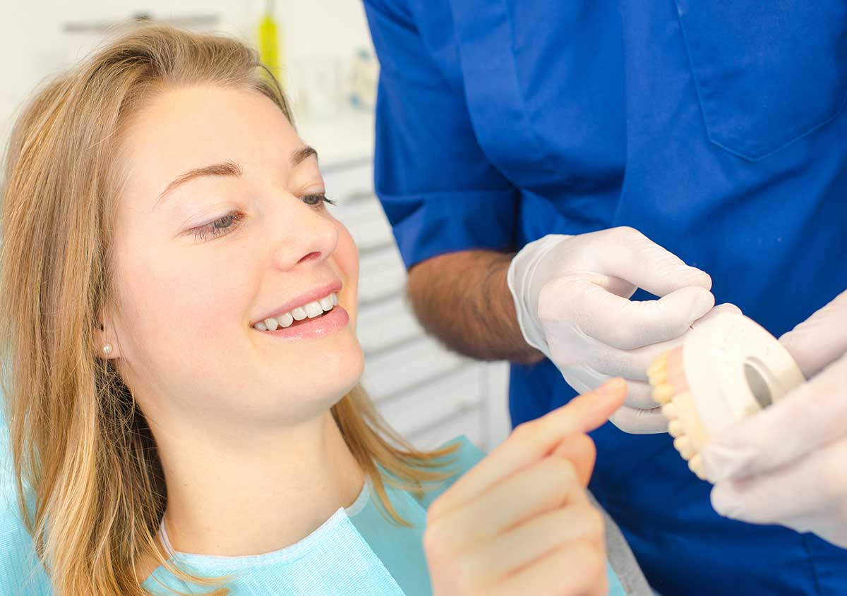 A female patient looking at the artificial tooth structure