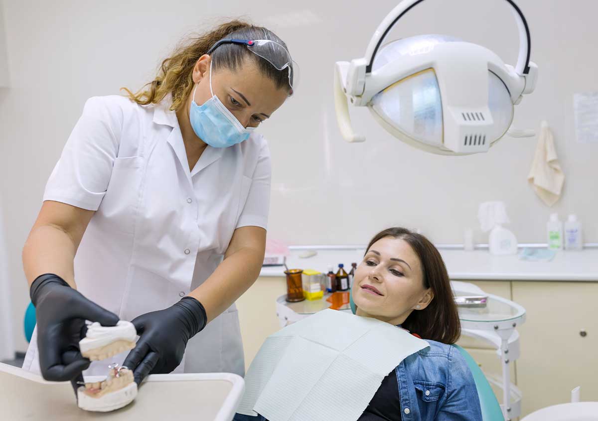 A dentist showing a teeth model to her patient